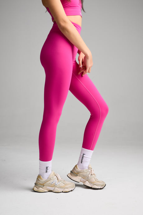 Person wearing high waisted bright pink leggings background